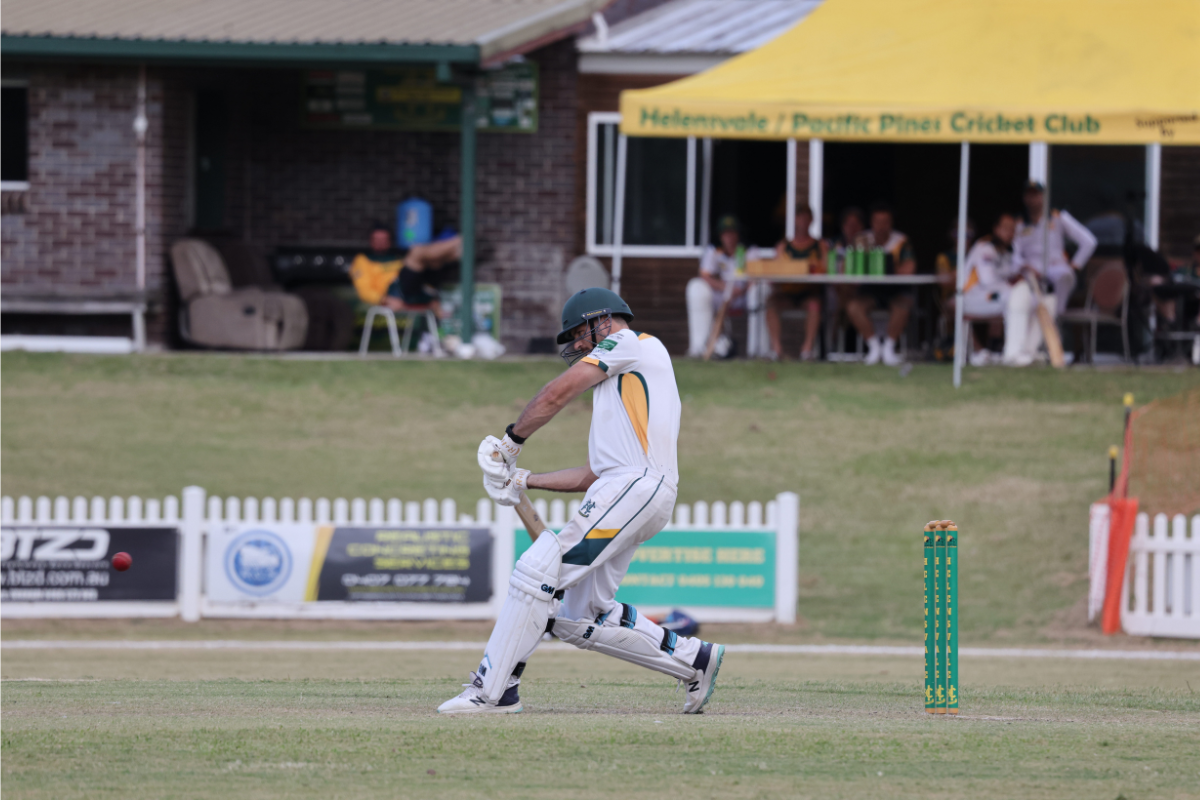 Hawks Cricket Club facilities behind cricketer playing a shot